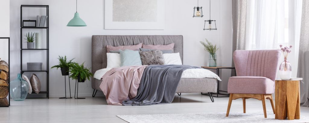 slaapkamer met roze zetel en modern bed