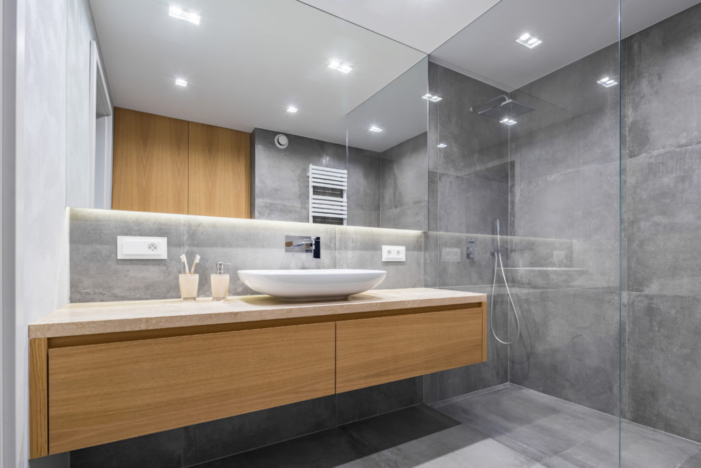 Badkamer betegeld met grijze tegel en moderne lavabo